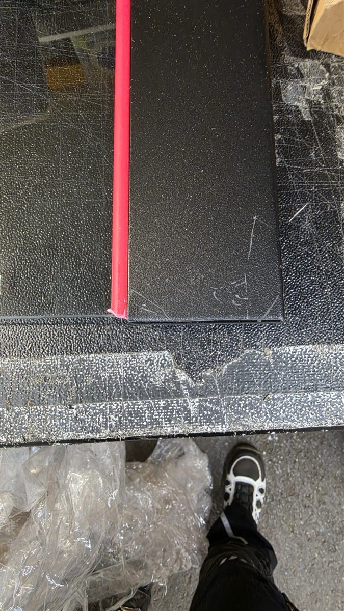 schwarze Schachtel, rote Rückenleiste, Kartonbox, strukturierte Oberfläche, Schuh zu sehen